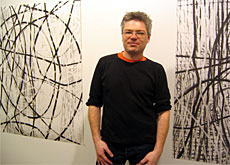 Oliver Krähenbühl with some of his charcoal drawings (swissinfo)